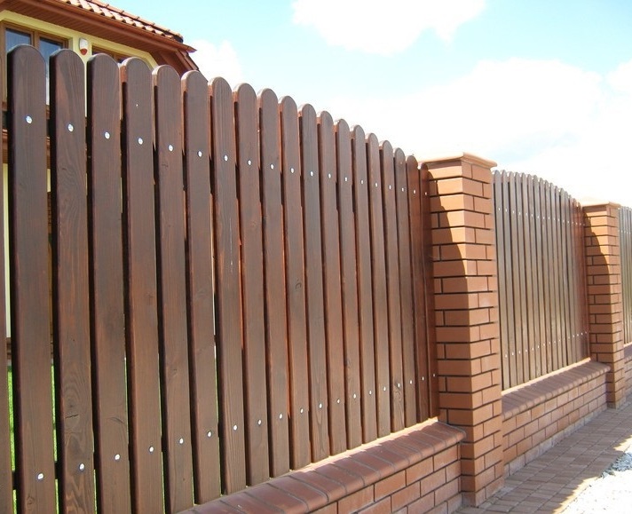Забор из красного кирпича и дерева на фундаменте для коттеджа