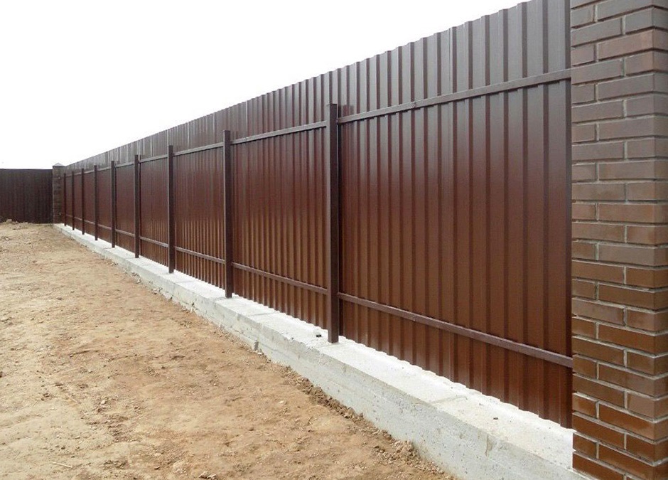Забор из коричневого профнастила на фундаменте