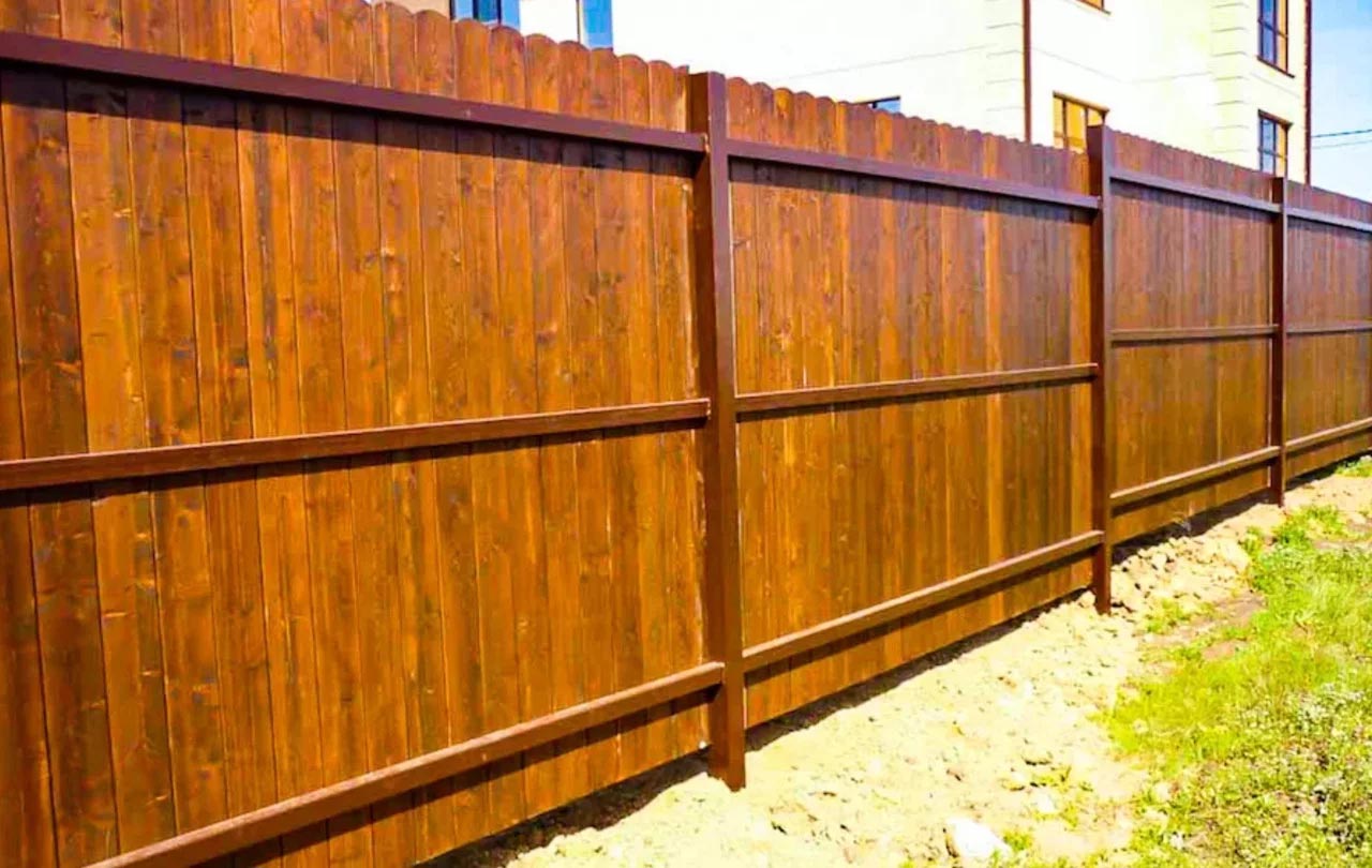 Сплошной деревянный забор с металлическим основанием