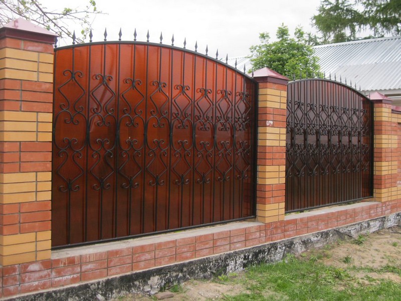 Секционный забор из поликарбоната, ковки и кирпича