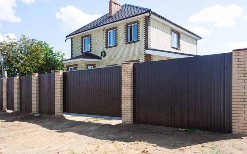 Кирпичный забор с профлистом с откатными воротами темно-коричневого цвета