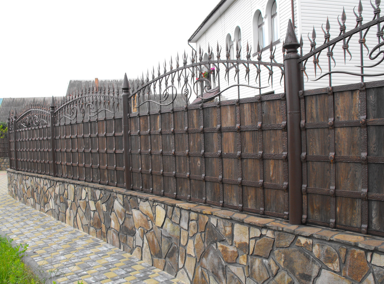 Комбинированный забор из дерева и металла с кованными элементами на металлических опорах
