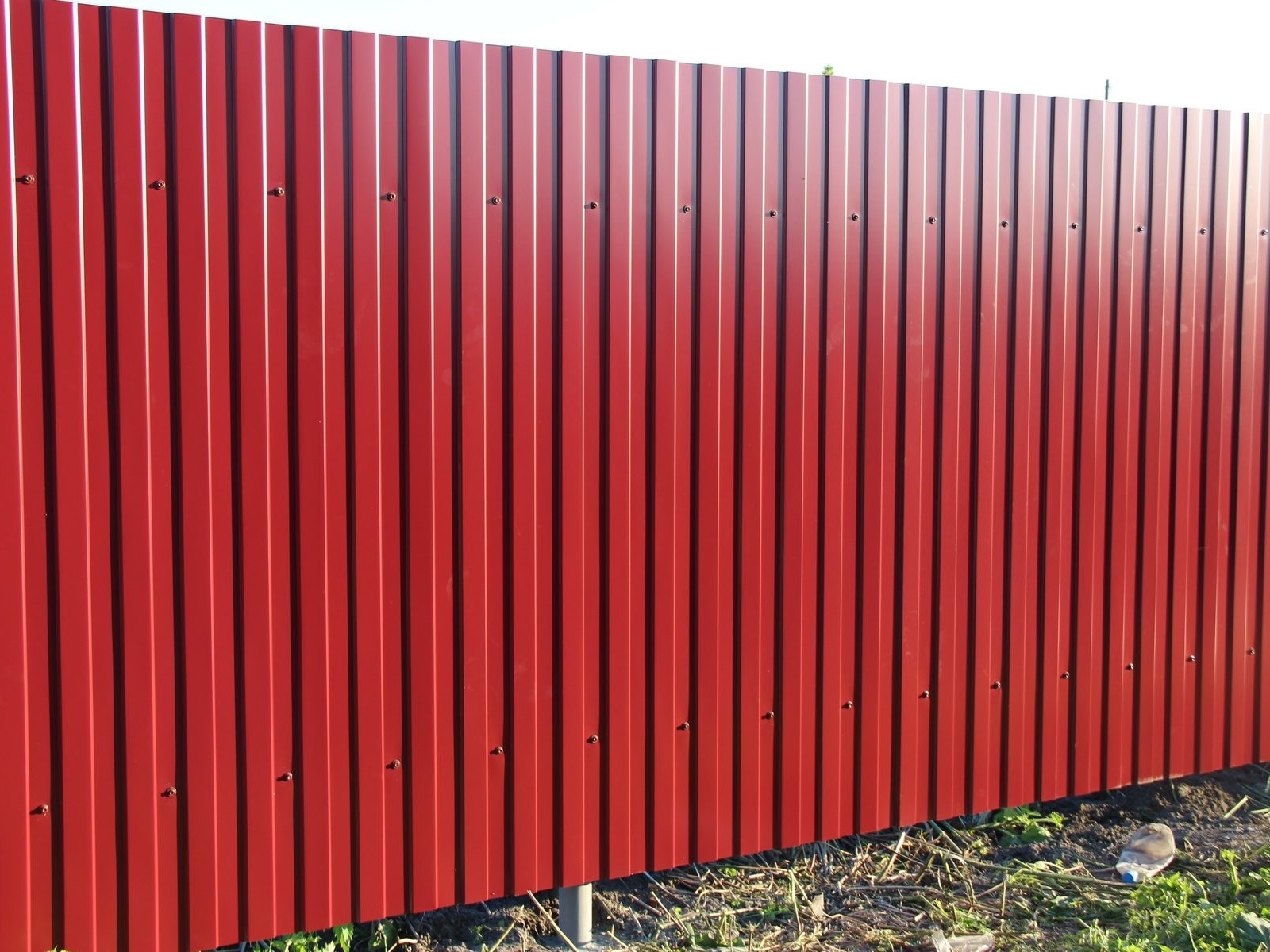 Металлический забор для дачи красного цвета на столбах